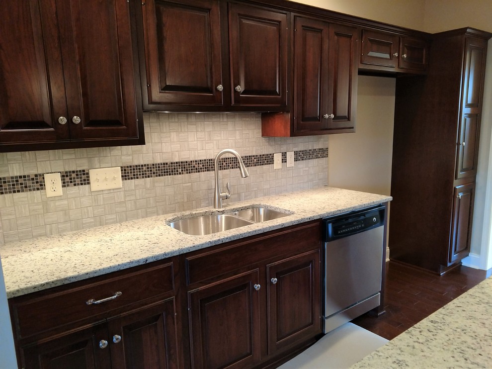 Kitchen - mid-sized transitional kitchen idea with an undermount sink, raised-panel cabinets, dark wood cabinets, quartz countertops, multicolored backsplash, ceramic backsplash, stainless steel appliances and an island