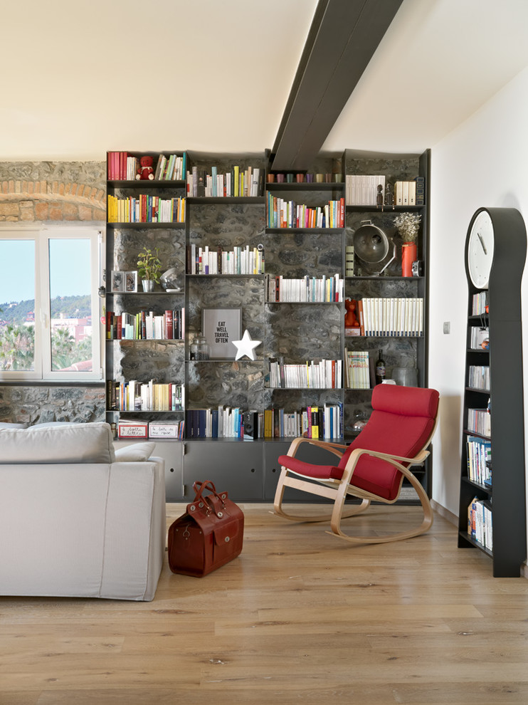 Design ideas for a mid-sized contemporary living room in Milan with a library, white walls and light hardwood floors.