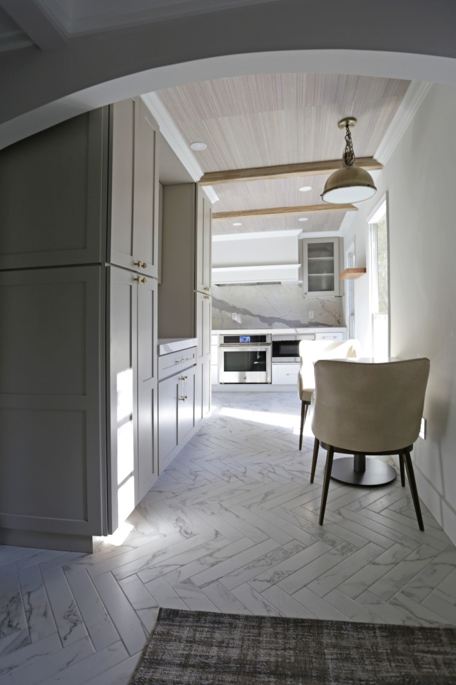 Example of a mid-sized transitional l-shaped marble floor, white floor and exposed beam kitchen design in DC Metro with an undermount sink, shaker cabinets, white cabinets, quartzite countertops, white backsplash, quartz backsplash and stainless steel appliances