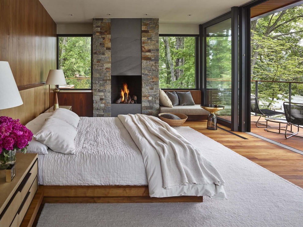 This is an example of a country master bedroom in DC Metro with medium hardwood floors and a standard fireplace.