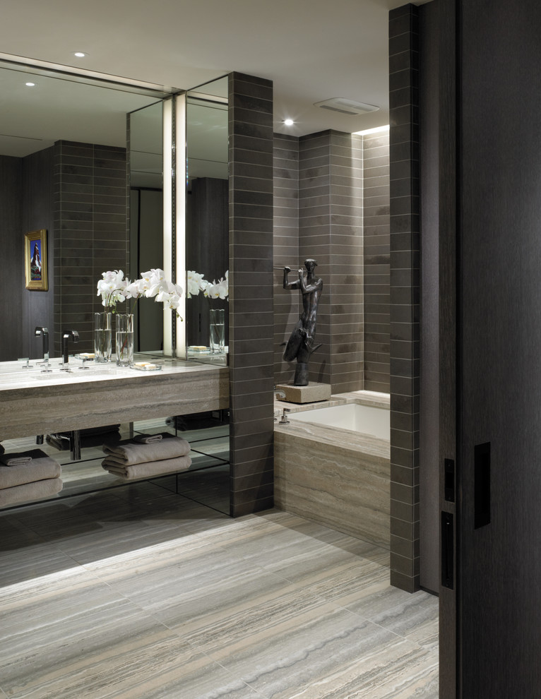 This is an example of a contemporary bathroom in New York with open cabinets, an alcove tub and gray tile.