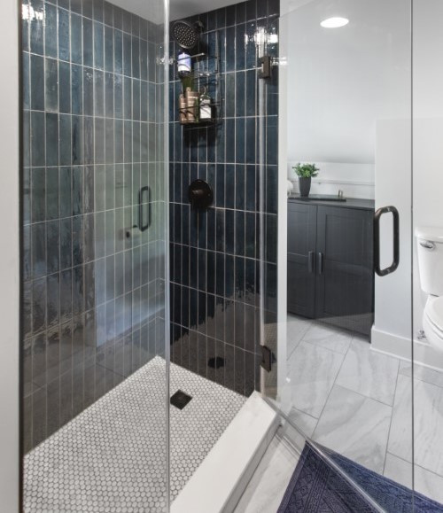 Inspiration for a modern bathroom in Columbus with flat-panel cabinets, medium wood cabinets, an alcove shower, a wall-mount toilet, blue tile, ceramic tile, white walls, ceramic floors, an undermount sink, engineered quartz benchtops, white floor, a hinged shower door, white benchtops, a niche, a single vanity, a built-in vanity and vaulted.