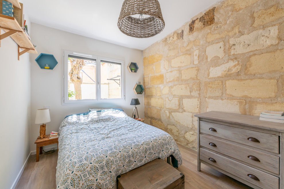 Mid-sized mediterranean master bedroom in Bordeaux with white walls, light hardwood floors and beige floor.
