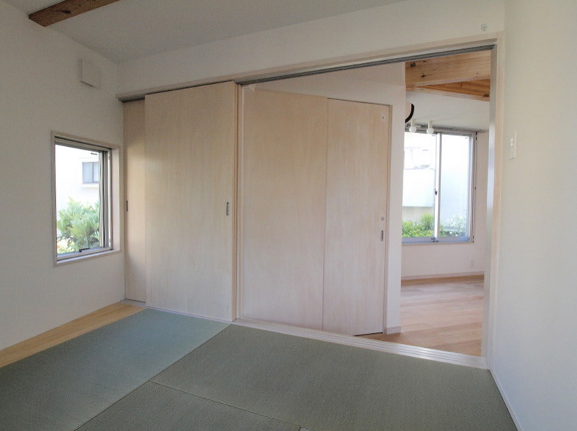Kleines Schlafzimmer mit weißer Wandfarbe, Tatami-Boden, Tapetendecke und Tapetenwänden in Tokio