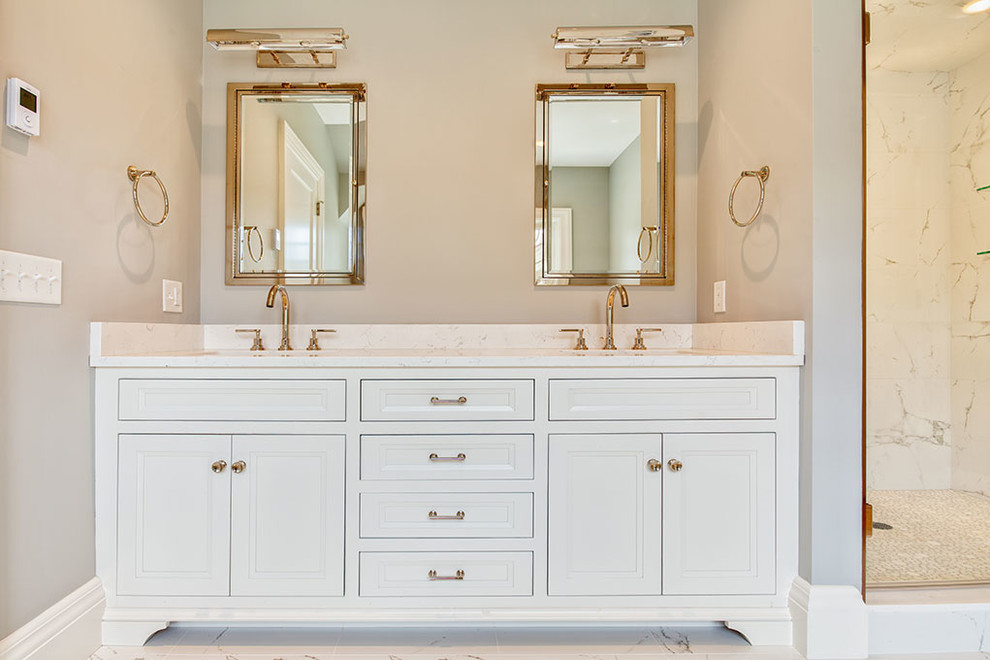 Example of a transitional master white floor freestanding bathtub design with recessed-panel cabinets, white cabinets, gray walls, an undermount sink, marble countertops and a hinged shower door