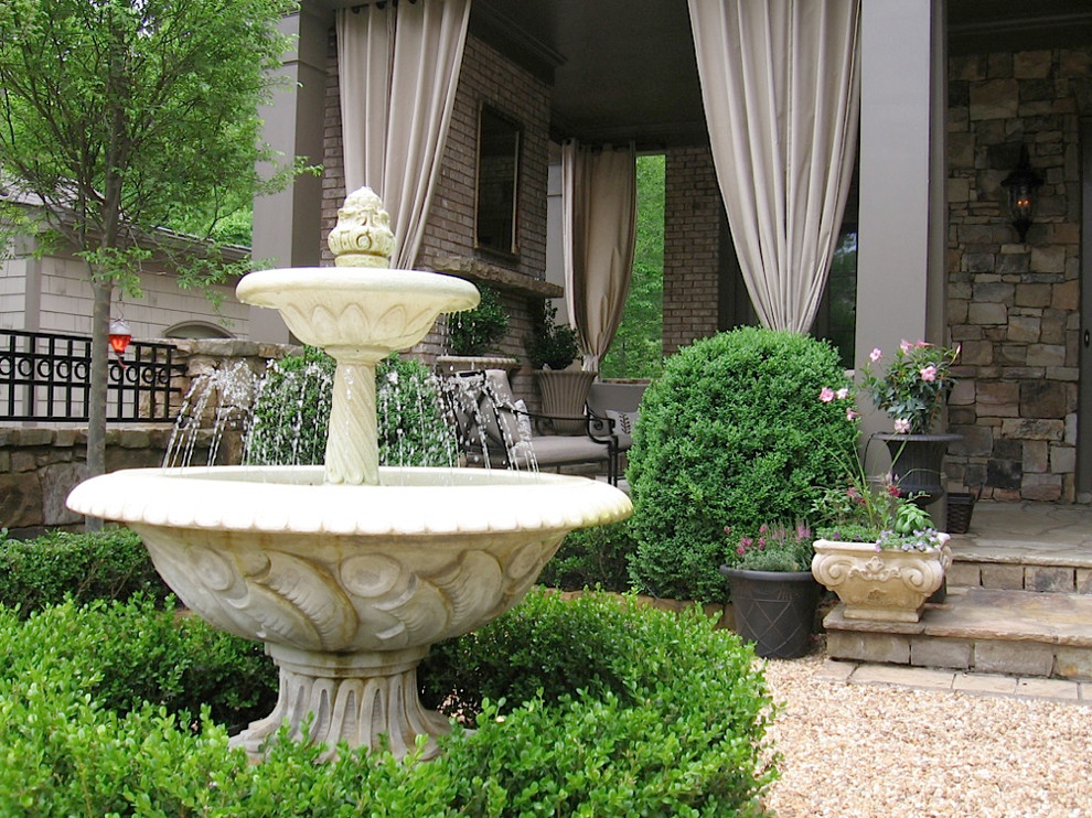 Inspiration for a large traditional backyard formal garden in Atlanta with a water feature and natural stone pavers.
