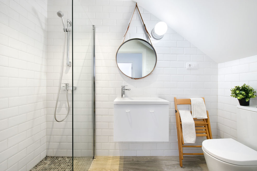 Inspiration for a small beach style 3/4 bathroom in Madrid with flat-panel cabinets, white cabinets, a corner shower, a one-piece toilet, white tile, subway tile, white walls, travertine floors and an integrated sink.