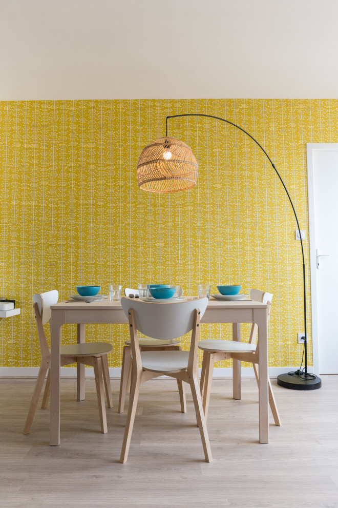 Esempio di una sala da pranzo scandinava con pareti gialle, parquet chiaro e carta da parati