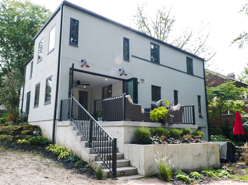 Diseño de fachada de casa gris de dos plantas con revestimiento de hormigón