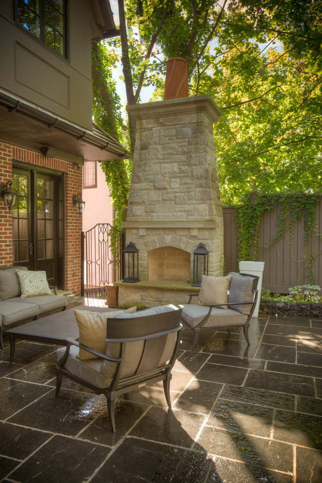 Inspiration for a medium sized classic back patio in Toronto with a fireplace, natural stone paving and no cover.