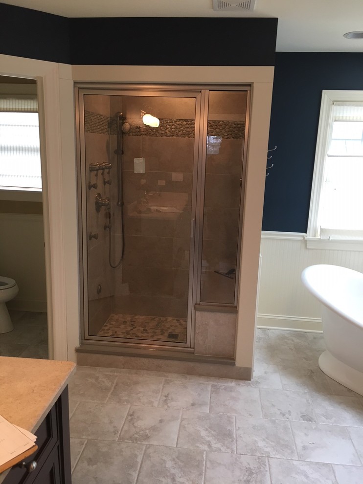 Inspiration for a mid-sized traditional master bathroom in Chicago with dark wood cabinets, a freestanding tub, a corner shower, brown tile, ceramic tile, black walls, ceramic floors, an undermount sink, granite benchtops, beige floor, a hinged shower door and brown benchtops.