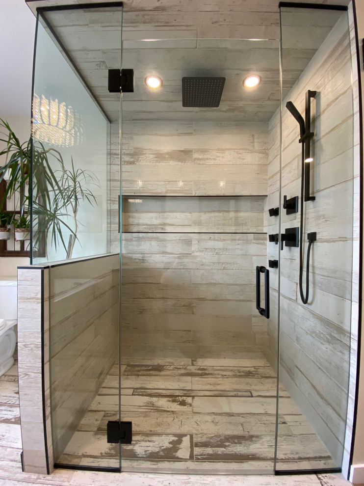 Photo of a transitional master bathroom in Calgary with shaker cabinets, brown cabinets, a freestanding tub, a curbless shower, a two-piece toilet, beige tile, ceramic tile, wood-look tile, an undermount sink, engineered quartz benchtops, beige floor, a hinged shower door, white benchtops, a niche, a double vanity and a built-in vanity.