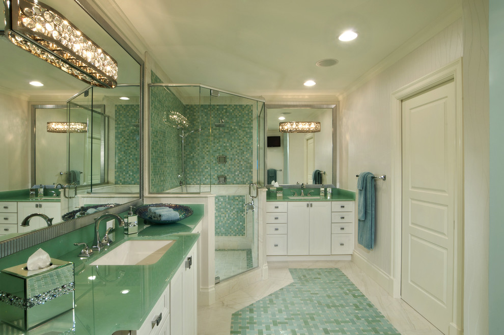 Photo of a large transitional bathroom in Miami with recessed-panel cabinets, white cabinets, a corner shower, blue tile, mosaic tile, white walls, marble floors, an undermount sink, glass benchtops, blue floor and a hinged shower door.