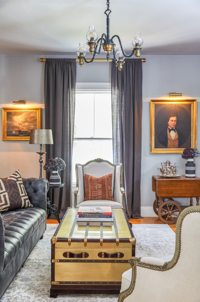 Photo of a traditional living room in Portland Maine with grey walls and light hardwood floors.