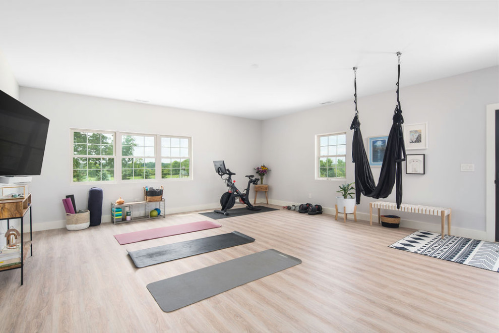 Photo of a transitional home gym in Columbus with grey walls and light hardwood floors.