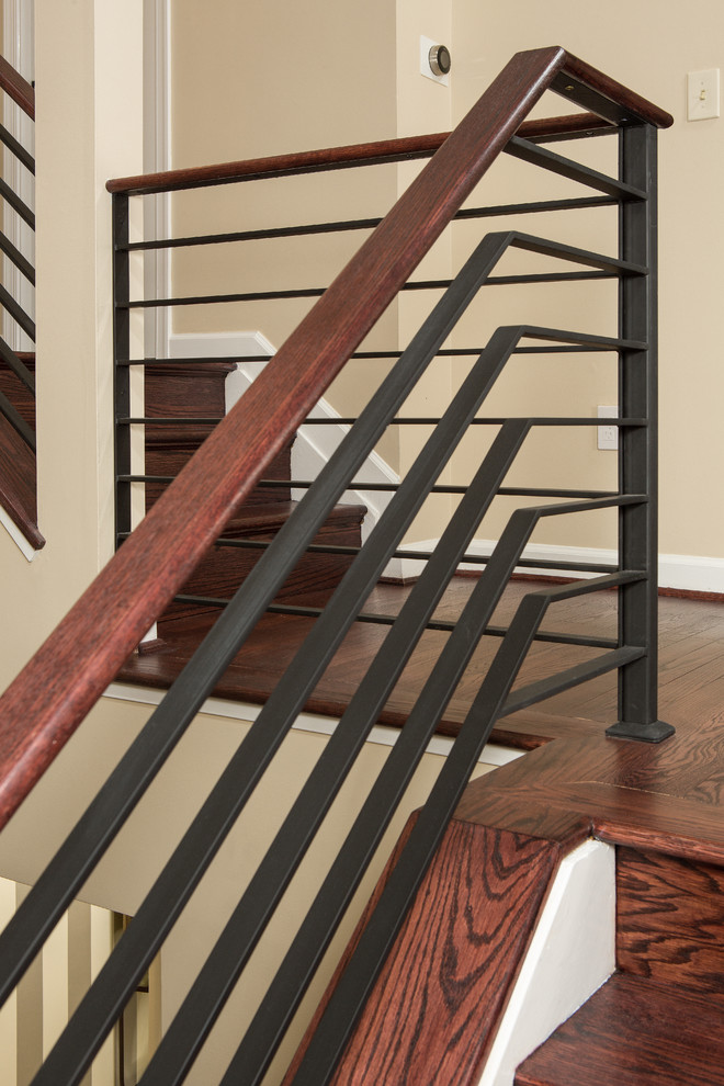 Design ideas for a large transitional wood spiral staircase in DC Metro with wood risers and metal railing.