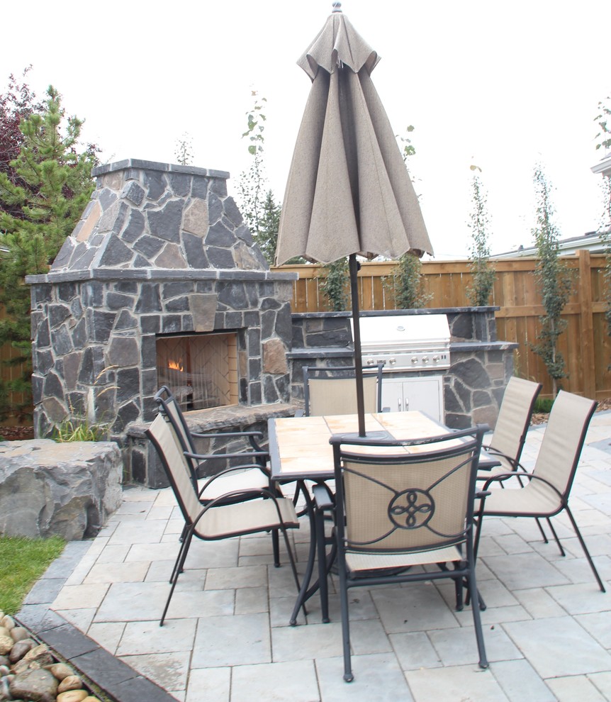 Inspiration for a mid-sized country backyard patio in Calgary with a fire feature and concrete pavers.