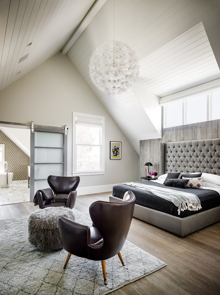 This is an example of a transitional bedroom in San Francisco with grey walls and light hardwood floors.