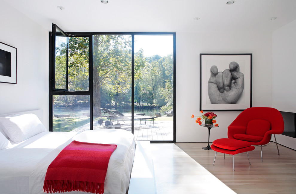 Contemporary bedroom in Atlanta with white walls and light hardwood floors.