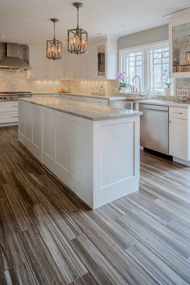 Example of a large transitional galley porcelain tile eat-in kitchen design in Chicago with a farmhouse sink, shaker cabinets, white cabinets, quartzite countertops, multicolored backsplash, glass sheet backsplash, stainless steel appliances and an island
