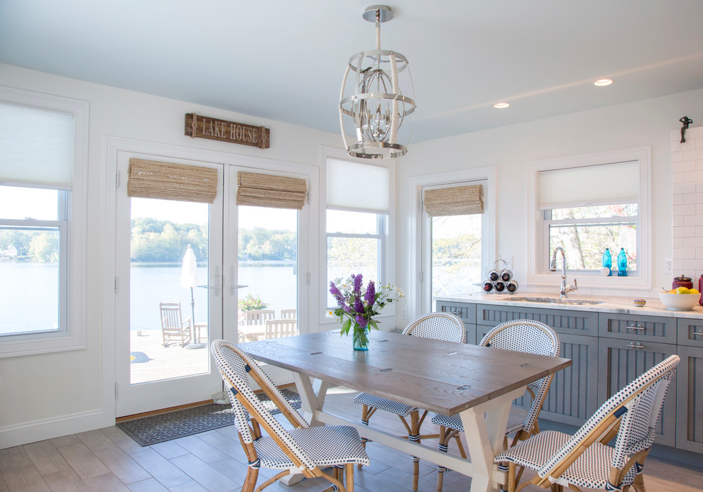 Kitchen/dining room combo - mid-sized coastal l-shaped porcelain tile kitchen/dining room combo idea in Bridgeport with a double-bowl sink, beaded inset cabinets, blue cabinets, quartzite countertops, white backsplash, subway tile backsplash, stainless steel appliances, no island, white walls and no fireplace