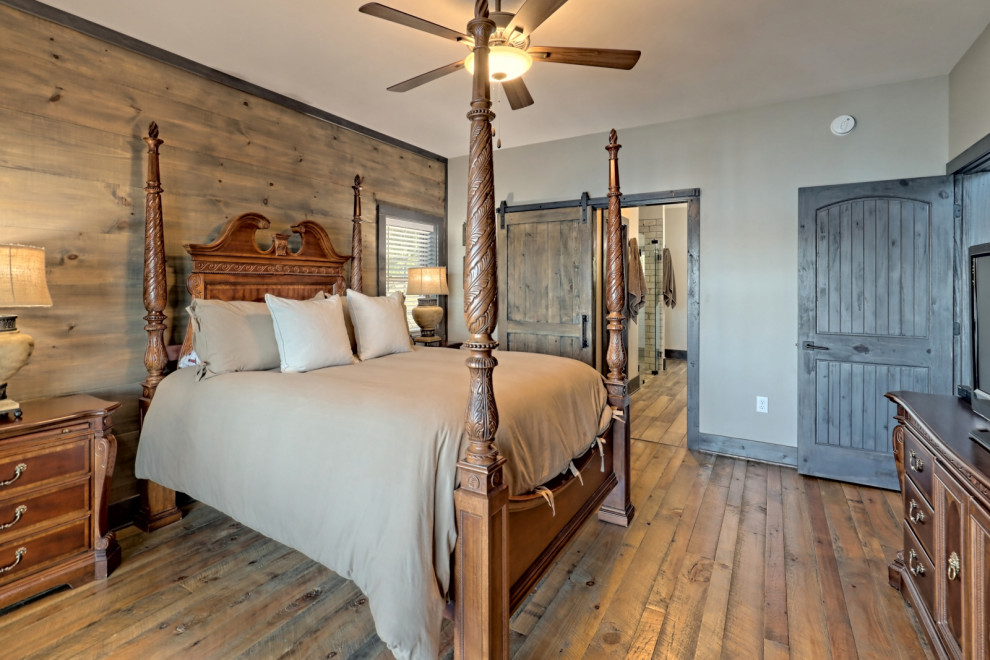 This is an example of a mid-sized arts and crafts master bedroom in Atlanta with grey walls, medium hardwood floors, grey floor and wood walls.