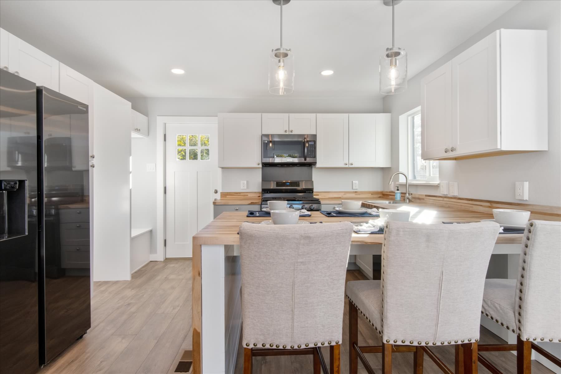 The centerpiece to the kitchen is the beautiful butcher block countertop and waterfall style breakfast bar