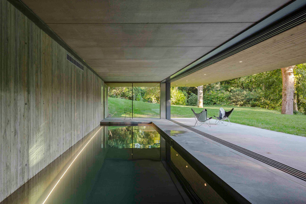 Design ideas for a large indoor rectangular pool in London with concrete slab.