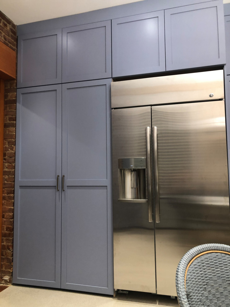 ニューヨークにある高級な小さなトラディショナルスタイルのおしゃれなランドリークローゼット (シェーカースタイル扉のキャビネット、青いキャビネット、クオーツストーンカウンター、白いキッチンパネル、クオーツストーンのキッチンパネル、赤い壁、トラバーチンの床、上下配置の洗濯機・乾燥機、ベージュの床、白いキッチンカウンター) の写真