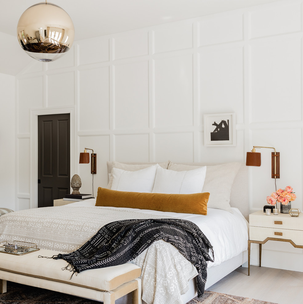 Inspiration for a beach style master bedroom with white walls, light hardwood floors and beige floor.