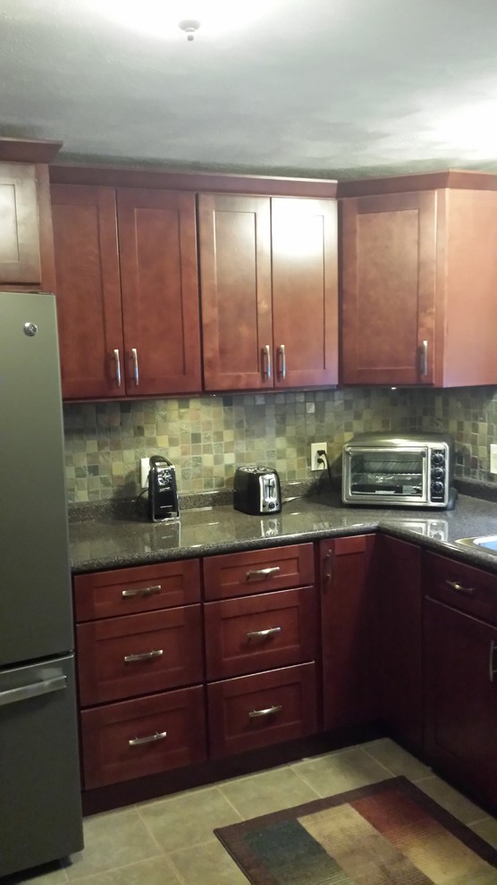 Mid-sized transitional l-shaped eat-in kitchen photo in Miami with a drop-in sink, recessed-panel cabinets, medium tone wood cabinets, granite countertops, beige backsplash, subway tile backsplash, stainless steel appliances and no island