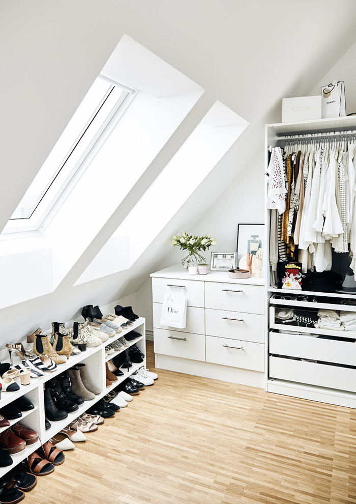 Mittelgroßes Nordisches Ankleidezimmer mit Ankleidebereich, flächenbündigen Schrankfronten, weißen Schränken, hellem Holzboden und beigem Boden in Hamburg