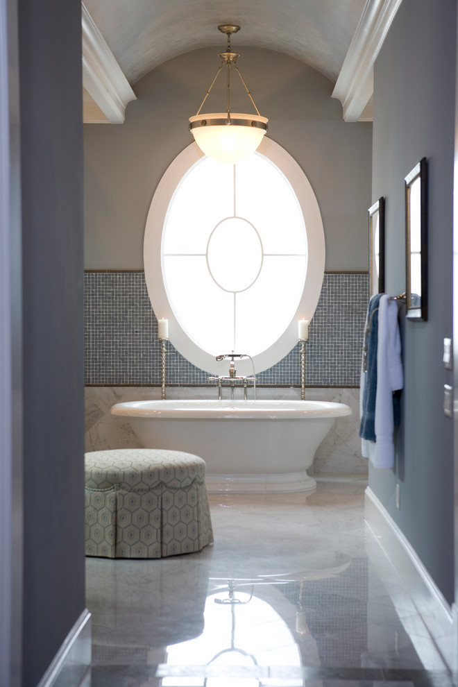 Inspiration for a traditional bathroom in Houston with a freestanding tub, gray tile and mosaic tile.