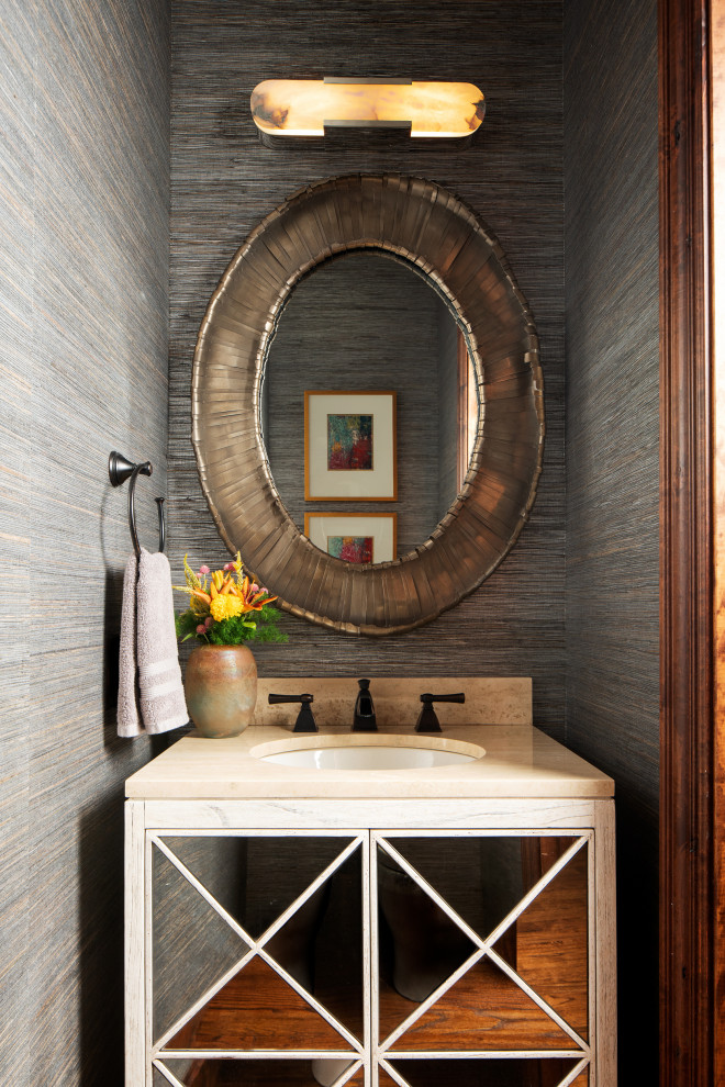 Design ideas for a mid-sized country powder room in Other with glass-front cabinets, beige cabinets, grey walls, dark hardwood floors, an undermount sink, travertine benchtops, beige benchtops, a freestanding vanity and wallpaper.