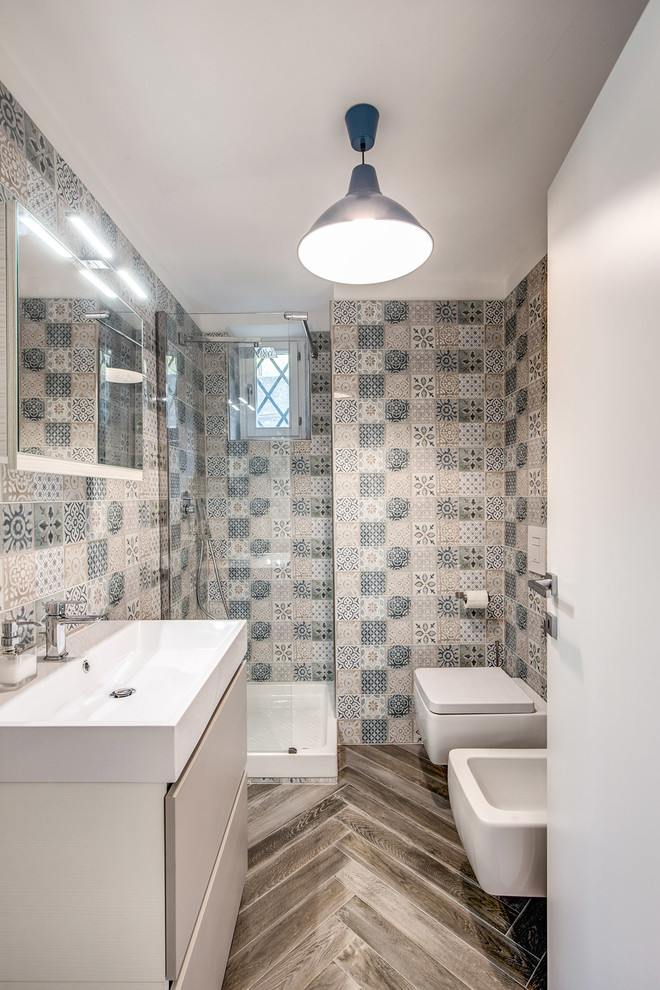 Photo of a small contemporary 3/4 bathroom in Other with flat-panel cabinets, beige cabinets, a bidet, multi-coloured tile, ceramic tile, multi-coloured walls, a trough sink and brown floor.