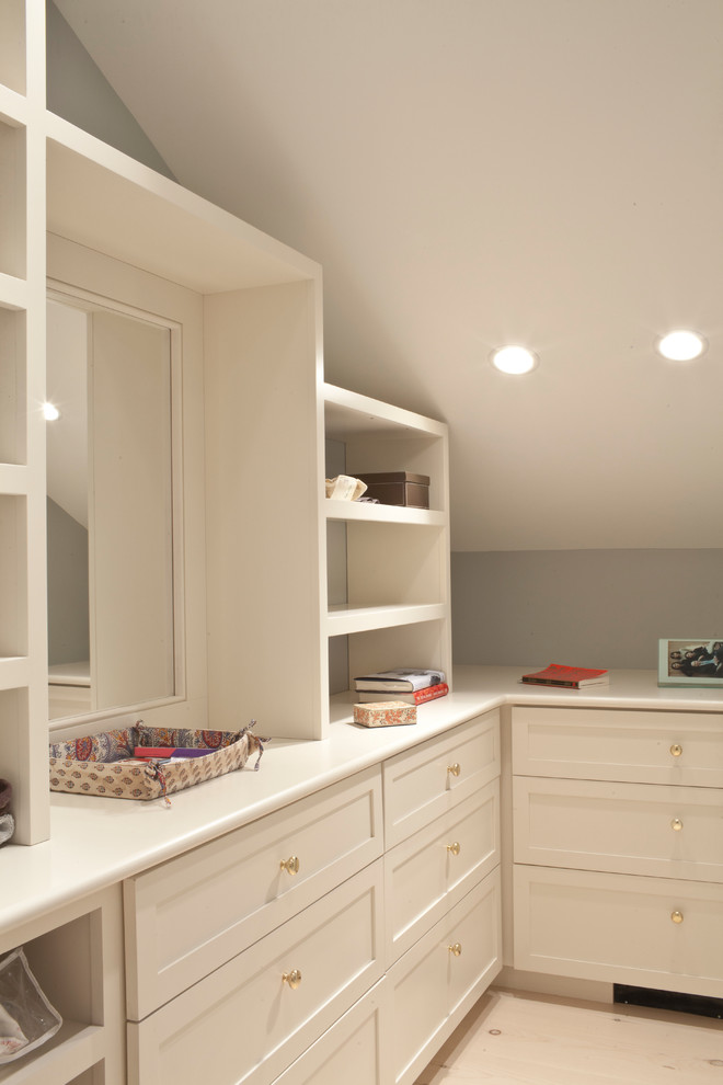 Large traditional gender-neutral dressing room in New York with shaker cabinets and white cabinets.