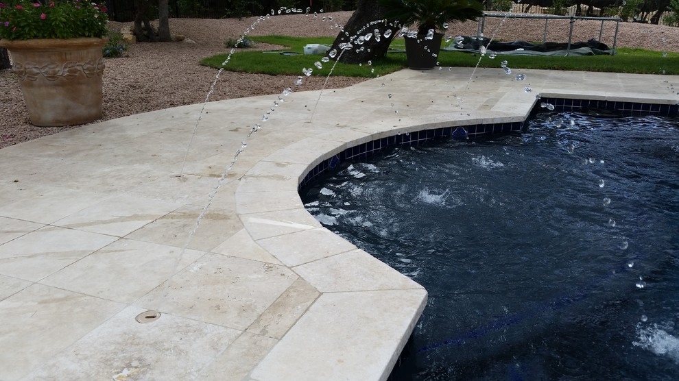 Expansive mediterranean backyard rectangular lap pool in Austin with a hot tub and stamped concrete.