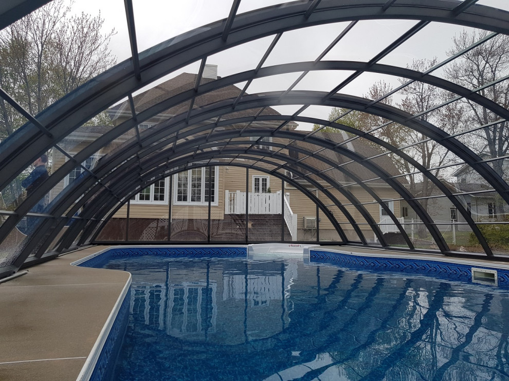 Réalisation d'une piscine arrière design en forme de haricot de taille moyenne avec des pavés en béton.
