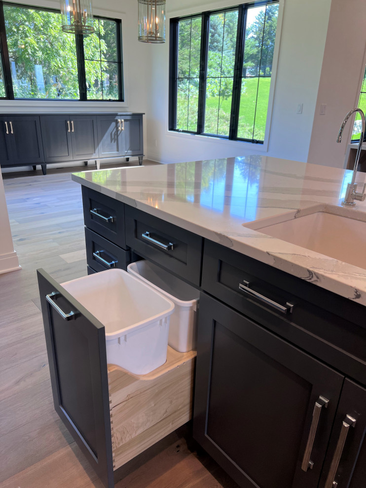 Large transitional kitchen photo with an undermount sink, shaker cabinets, gray cabinets, quartz countertops, white backsplash, stainless steel appliances, two islands and white countertops
