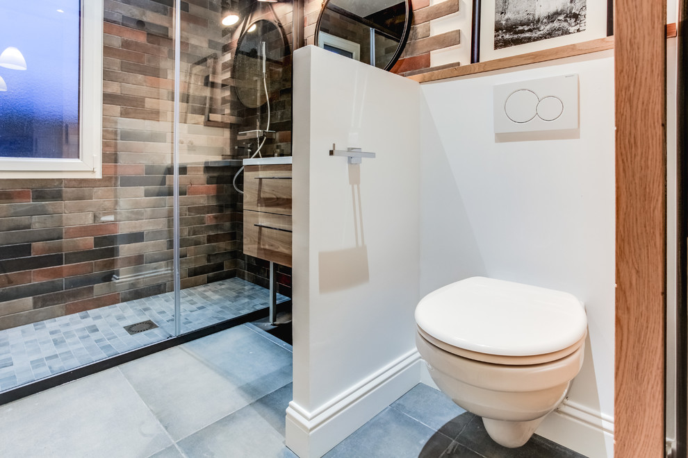 Photo of a mid-sized contemporary master bathroom in Bordeaux with a wall-mount toilet, gray tile, grey floor, a curbless shower, matchstick tile, white walls, a vessel sink and a sliding shower screen.