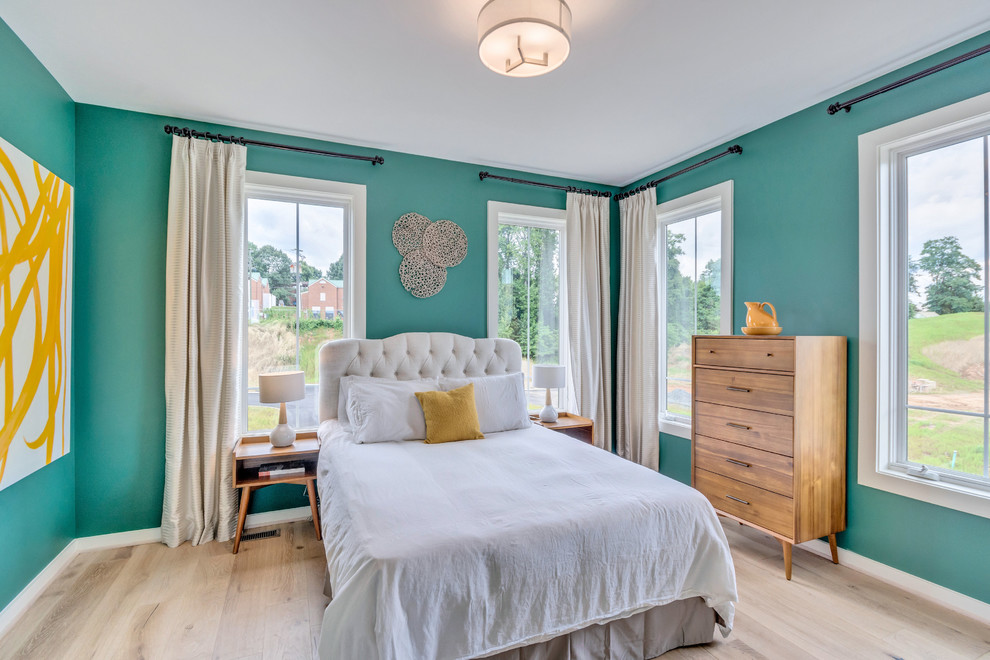 This is an example of a transitional guest bedroom in DC Metro with blue walls and light hardwood floors.