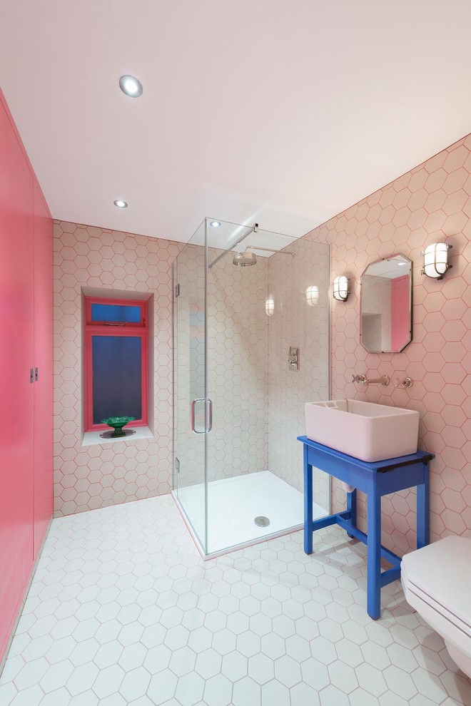 Inspiration for a contemporary 3/4 bathroom in London with a vessel sink, blue cabinets, a corner shower, white tile and pink walls.