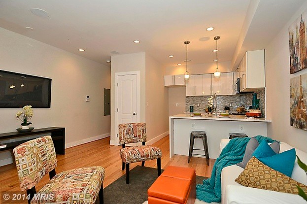 Example of a transitional u-shaped light wood floor eat-in kitchen design in DC Metro with an undermount sink, flat-panel cabinets, white cabinets, quartz countertops, multicolored backsplash, mosaic tile backsplash, stainless steel appliances and a peninsula