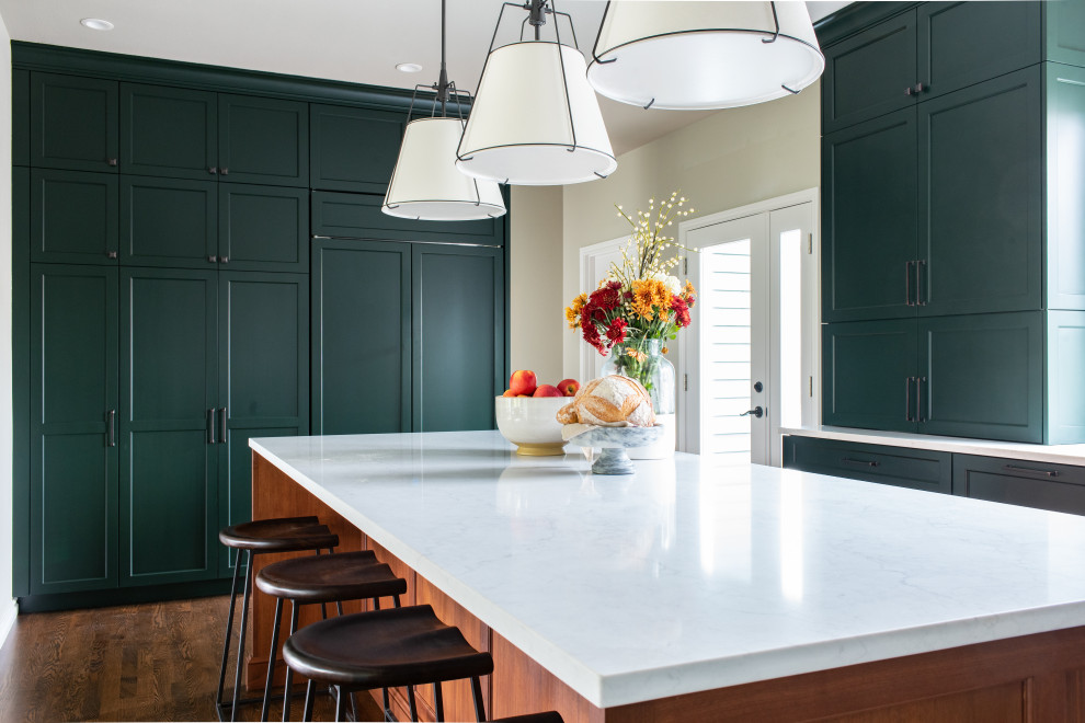 Mid-sized transitional l-shaped dark wood floor and brown floor eat-in kitchen photo in Seattle with a farmhouse sink, shaker cabinets, green cabinets, white backsplash, subway tile backsplash, paneled appliances, an island, green countertops and quartz countertops