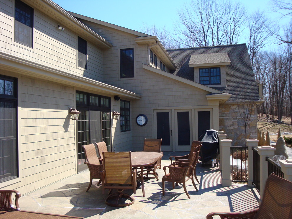 This is an example of a large traditional two-storey beige exterior in Other with wood siding.