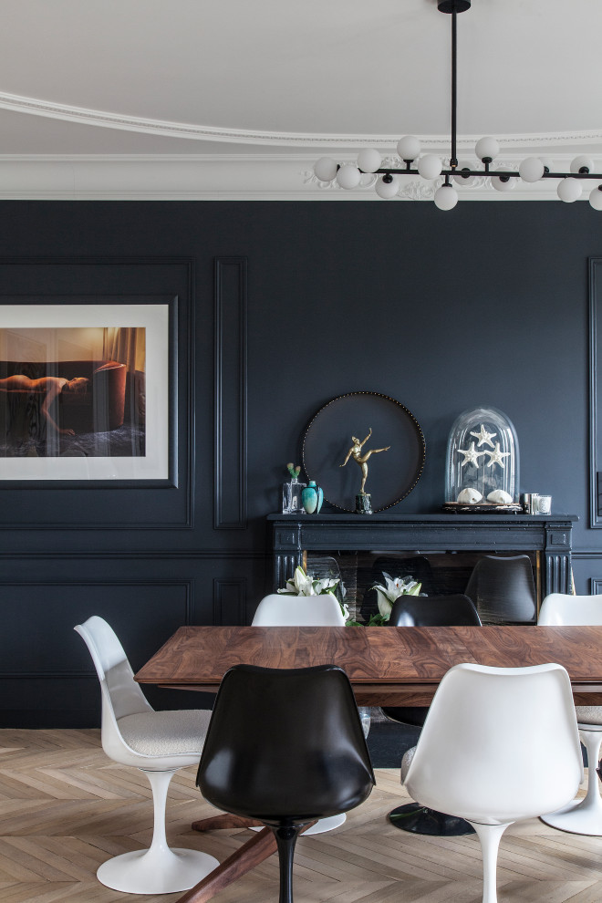 Inspiration for a large contemporary open plan dining in Paris with white walls, medium hardwood floors, a standard fireplace, a stone fireplace surround, brown floor and decorative wall panelling.