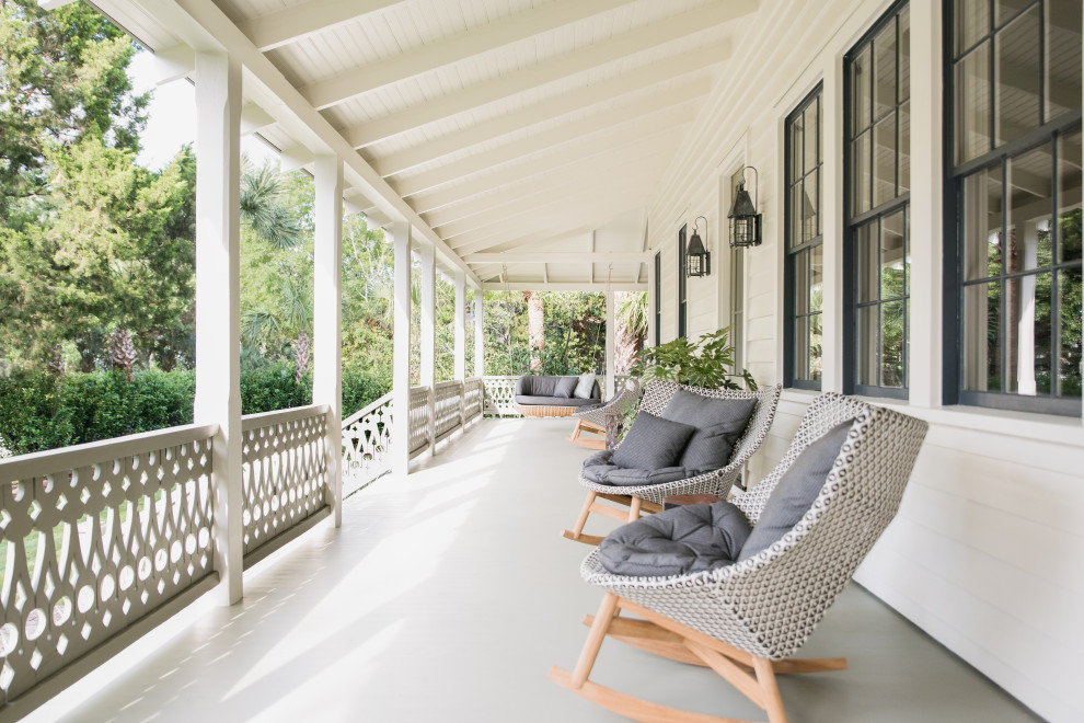 Sullivan's Island Remodel - Exterior porch on historic Sullivan's Island home. Exposed rafters, custom-milled nostalgic stair railing, Marvin black clad windows, decorative lanterns and painted deck flooring.