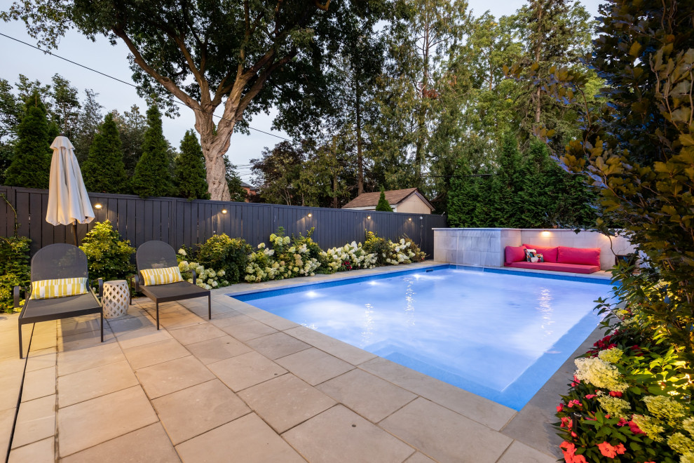 Ejemplo de piscina actual pequeña rectangular en patio trasero con paisajismo de piscina y adoquines de piedra natural