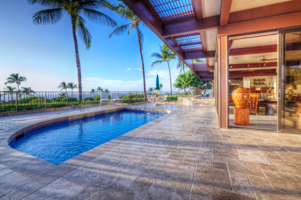 Inspiration for a mid-sized modern backyard custom-shaped lap pool in Hawaii with natural stone pavers.