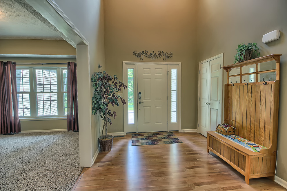 Inspiration for a mid-sized traditional entry hall in Columbus with beige walls, light hardwood floors, a single front door and a white front door.